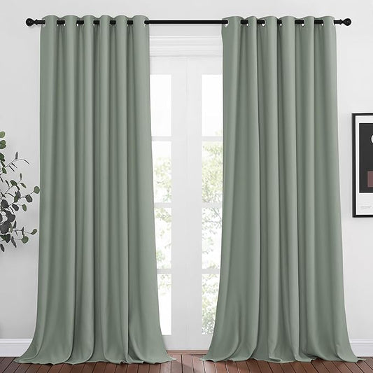 Sage green textured grommet curtain panels hanging at a large window